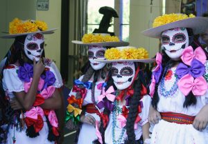 Young girls wear masks during the celebration.