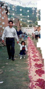 Un padrre con su hijita caminan a un lado de los tapetes